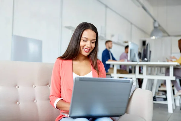 Lycklig kvinna med laptop som arbetar på kontor — Stockfoto