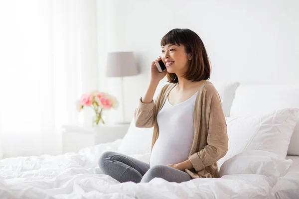 Glad gravid kvinna ringer på smartphone hemma — Stockfoto