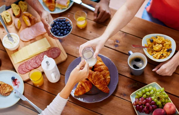 Pessoas tomando café da manhã à mesa com alimentos — Fotografia de Stock