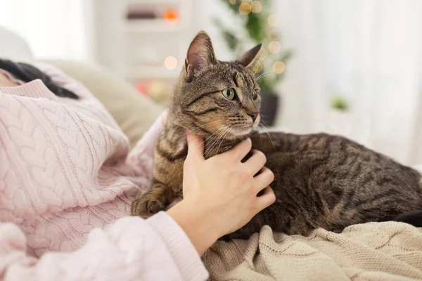 Close up of owner with tabby cat in bed at home — Stock Photo, Image