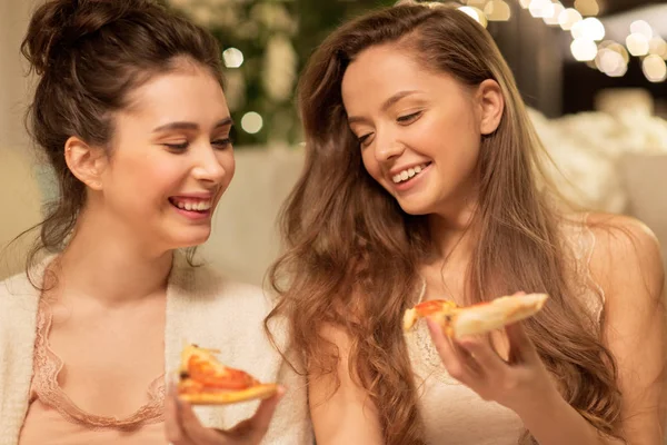 Happy female friends eating pizza at home — Stock Photo, Image