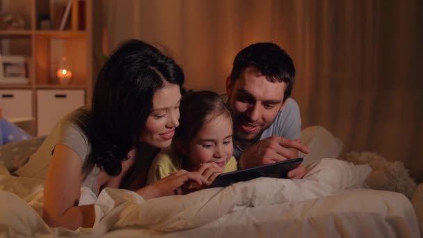 Family with tablet pc in bed at night at home — Stock Video