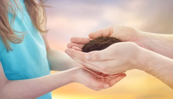 Close up of father and daughter hands holding soil — Stock Photo, Image