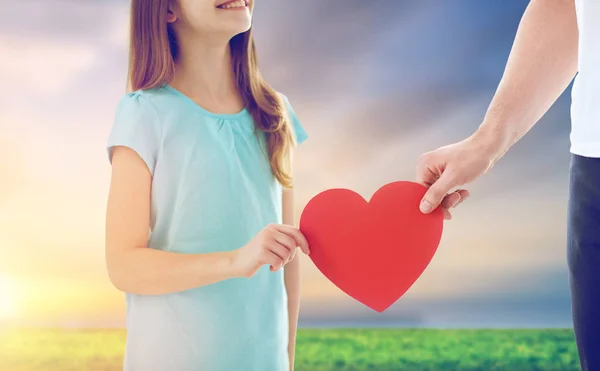 Primer plano de la hija y el padre sosteniendo el corazón rojo — Foto de Stock