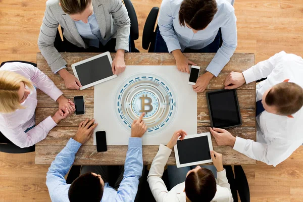Equipo de negocios con bitcoin holgram en la mesa — Foto de Stock