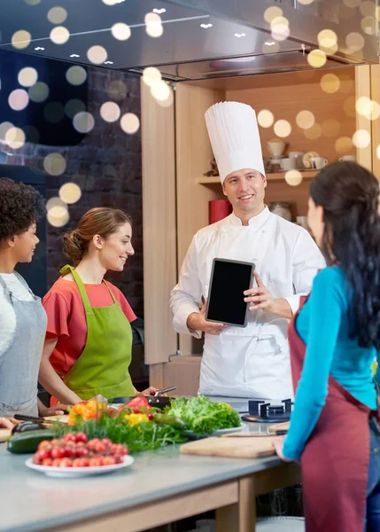 Mulheres felizes com chef e tablet pc na cozinha — Fotografia de Stock