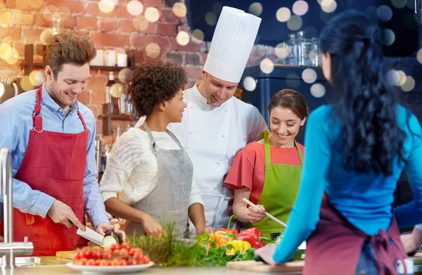 Amigos felices y cocinero cocinar en la cocina — Foto de Stock