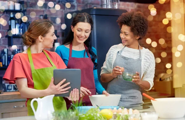 Šťastné ženy s tablet pc, vaření v kuchyni — Stock fotografie