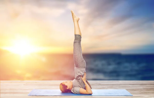 Mujer haciendo yoga en hombrostand pose en la estera —  Fotos de Stock