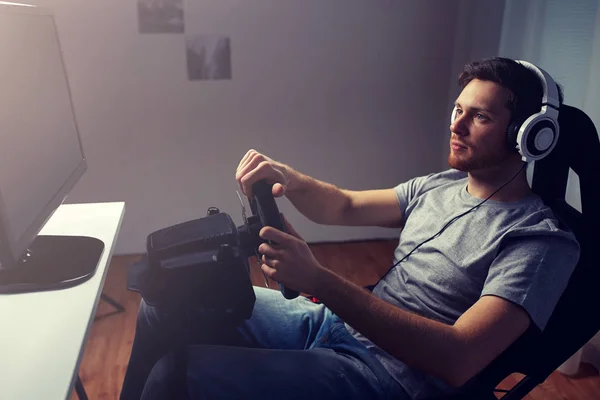 Uomo che gioca auto da corsa video gioco a casa — Foto Stock