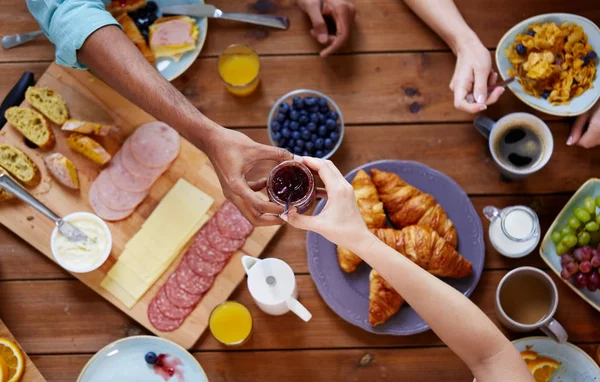 Personnes prenant le petit déjeuner à table avec de la nourriture — Photo