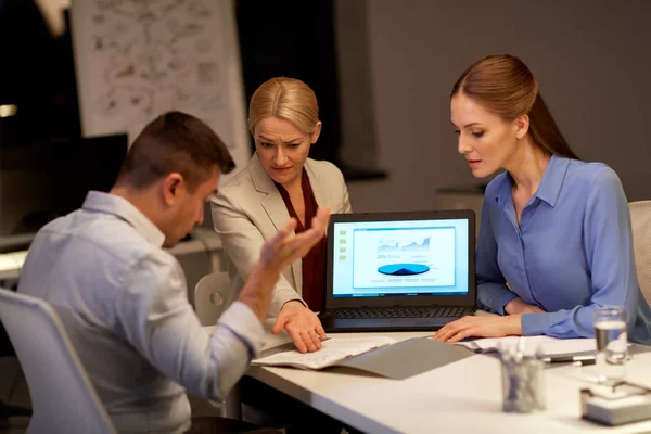 Business-team med laptop arbetar på natten kontor — Stockfoto