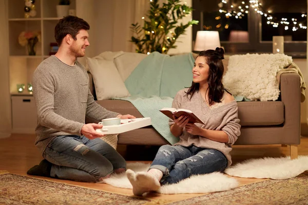 Lyckliga par med bok och mat hemma — Stockfoto