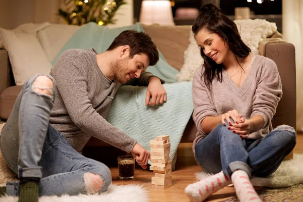 Feliz pareja jugando bloque-apilamiento juego en casa — Foto de Stock