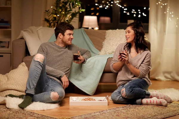 Feliz pareja bebiendo café y comiendo en casa — Foto de Stock