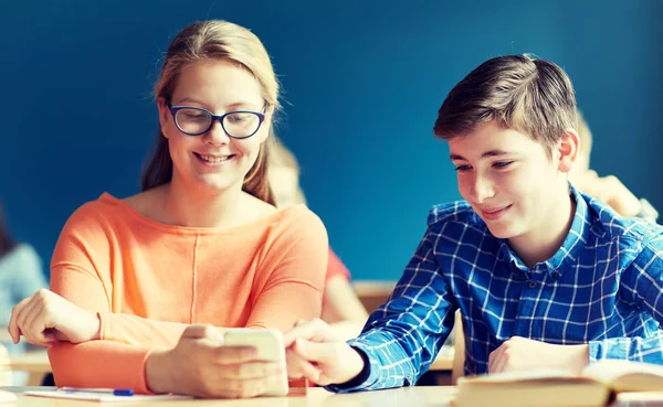 Studenter med smartphone textning i skolan — Stockfoto