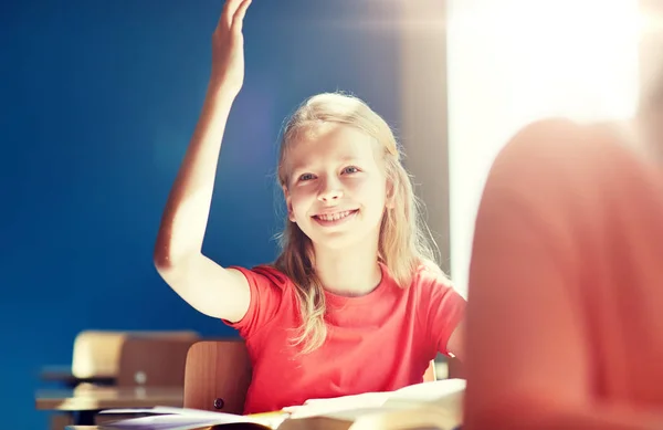 Щаслива студентська дівчина піднімає руку на уроці школи — стокове фото
