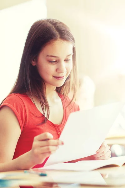 Chica estudiante feliz con papel de prueba en la escuela —  Fotos de Stock