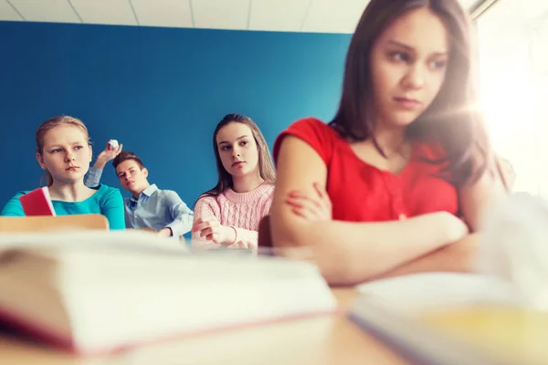 Estudiantes chismorreando detrás de su compañero de clase en la escuela — Foto de Stock