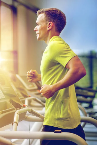Uśmiechnięty mężczyzna ćwiczenia na bieżni w siłowni — Zdjęcie stockowe