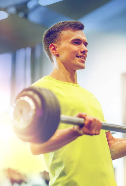 Homme souriant faisant de l'exercice avec haltère dans la salle de gym — Photo