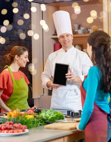 Happy women with chef and tablet pc in kitchen — Stock Photo, Image
