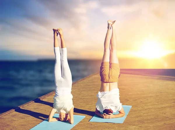 Par gör yoga Huvudstående på matta utomhus — Stockfoto