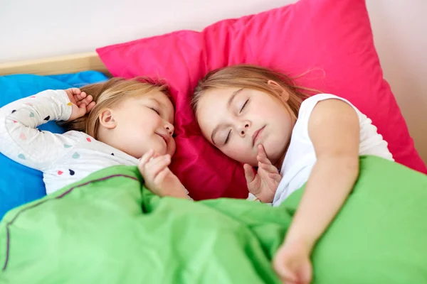 Meninas felizes dormindo na cama em casa — Fotografia de Stock