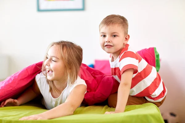 Niños pequeños y felices tumbados en el suelo o la alfombra — Foto de Stock