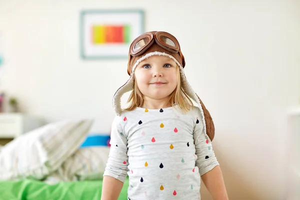 Menina feliz em chapéu piloto jogando em casa — Fotografia de Stock