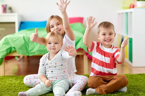 Группа счастливых детей, сидящих на полу дома — стоковое фото