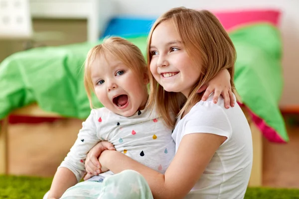 Happy little girls or sisters hugging at home Royalty Free Stock Photos