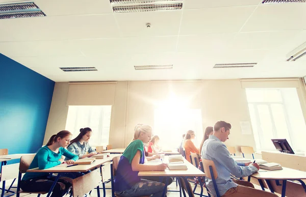 Groupe d'étudiants avec des livres écrit test scolaire — Photo