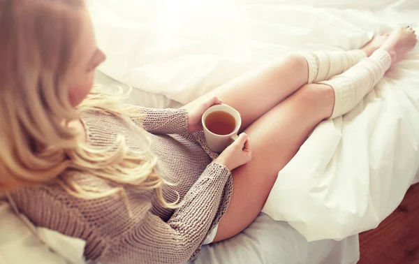 Primo piano della donna con tazza di tè a letto — Foto Stock