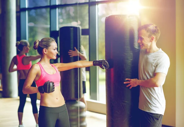 Mujer sonriente con entrenador personal boxeo en el gimnasio —  Fotos de Stock