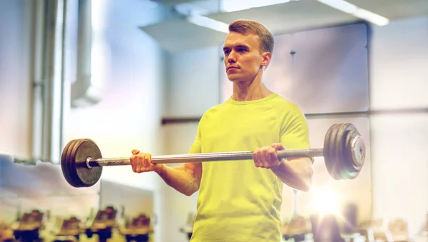 Man doing exercise with barbell in gym — Stock Photo, Image