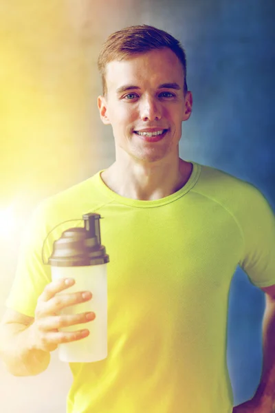 Усміхнений чоловік з пляшкою білкового струшування — стокове фото
