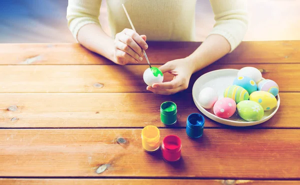 Close up of woman hands coloring easter eggs — Stock Photo, Image