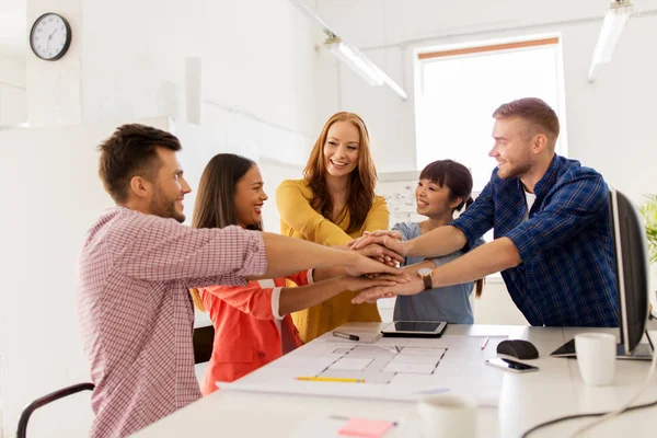 Kreativa teamet håller händerna ihop på kontoret — Stockfoto