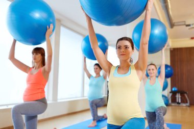 pregnant women training with exercise balls in gym clipart