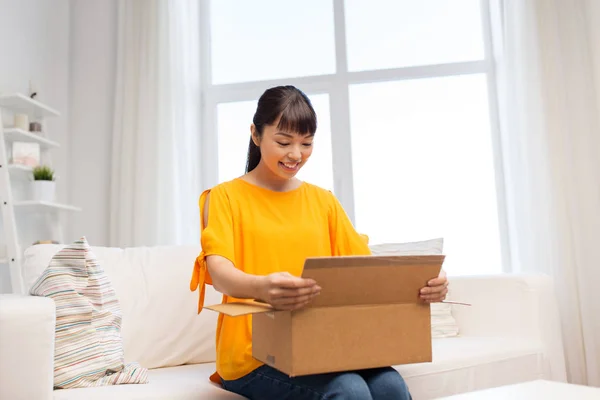 Feliz asiático joven mujer con paquete caja en casa —  Fotos de Stock
