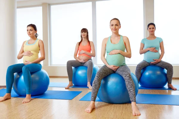Spor salonunda egzersiz topları üzerinde oturan hamileler — Stok fotoğraf