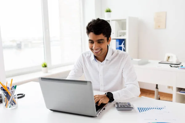 Бізнесмен з ноутбуком і паперами в офісі — стокове фото