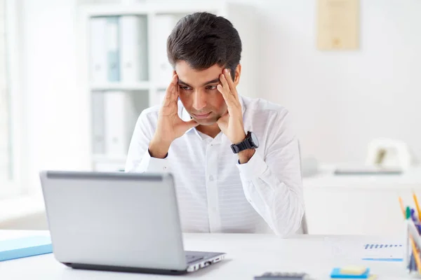 Stressed businessman with laptop at office — Stock Photo, Image