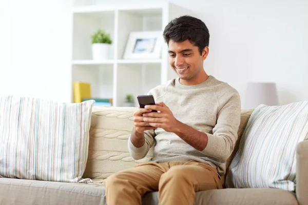 Hombre feliz con smartphone en casa —  Fotos de Stock