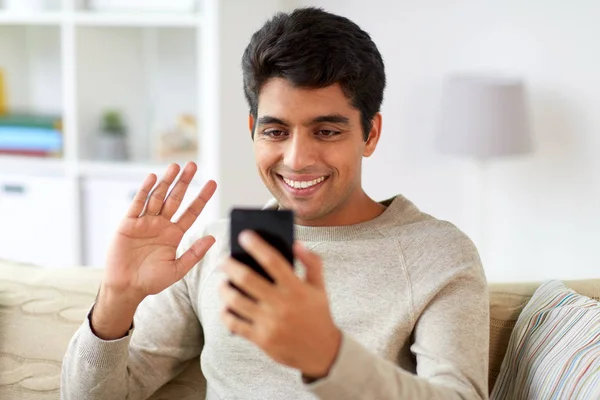 Homme heureux ayant appel vidéo sur smartphone à la maison — Photo