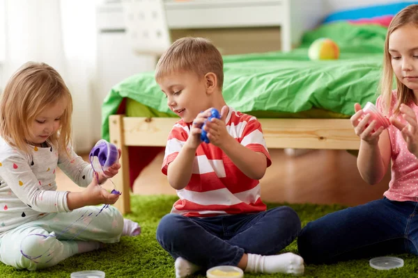 Little kids with modelling clay or slimes at home — Stock Photo, Image
