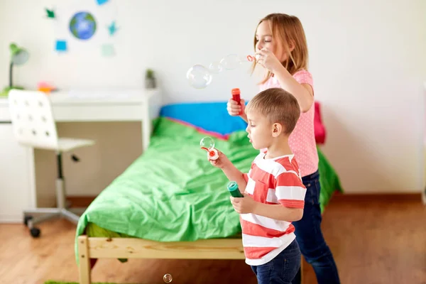 Kinder blasen Seifenblasen und spielen zu Hause — Stockfoto