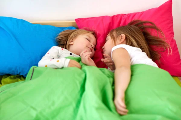 Niñas felices durmiendo en la cama en casa —  Fotos de Stock