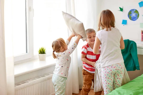 Дети играют и дерутся на подушках дома — стоковое фото